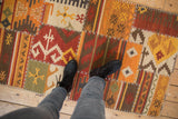Patchwork Kilim rug with distinct cross-hatch stitching and primitive geometric panel designs.