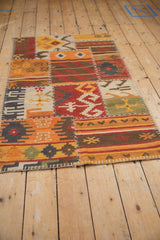 A perspective view of the warm-toned patchwork kilim showing its various geometric panels.