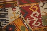 A folded corner on a patchwork kilim rug displays its raised cross-hatch stitch construction.