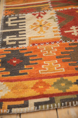 Patchwork Kilim detail showing geometric rams horn motifs and white cross-hatch stitching.