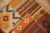 Patchwork kilim rug detail with cross-hatch stitches, geometric and primitive patterns in a warm palette.