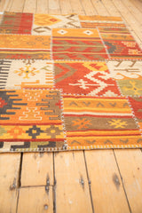 Warm geometric patchwork kilim with varied panels, finned guls, and visible cross-stitch seams.