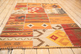 Geometric panels and distinctive white cross-stitch seams of a patchwork kilim.
