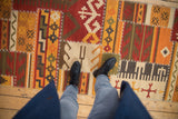 Close-up of patchwork kilim runner with primitive geometric motifs and white cross-stitch seams.