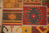 Geometric primitive patchwork Kilim runner detail with warm tones and ivory cross hatch stitches.