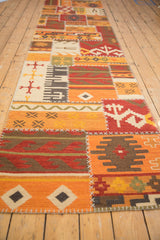 Patchwork Kilim runner detail with geometric panels, warm tones, and white cross-stitching.