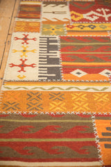 Close view of patchwork kilim runner's geometric panels joined by raised cross-hatch stitches.