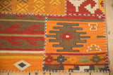 Raised ivory cross-stitching joins panels of a geometric patchwork kilim in warm earth tones.