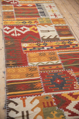 Angled view of the patchwork kilim runner's geometric panels and raised, decorative cross-hatch stitching.