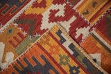 Raised cross-hatch stitches join geometric panels on a warm-toned patchwork kilim rug.