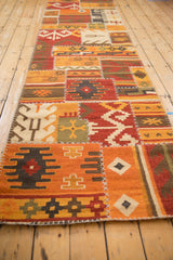 Long perspective of a geometric patchwork kilim runner with a warm, earthy palette.