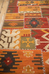 Detail of a patchwork kilim with raised cross-hatch stitches and warm-toned geometric panels.