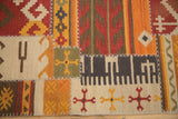 Geometric patterns and raised ivory cross-hatch stitching on a handwoven patchwork kilim rug.