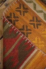 A corner detail of the patchwork kilim's flatweave, highlighting the raised cross-hatch seam stitches.