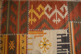 Geometric saffron yellow, brick red, and ivory patterns with white cross-stitch patchwork.