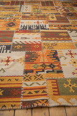 Geometric patchwork Kilim detail with warm-toned panels, primitive guls, and prominent white stitching.