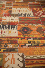 Geometric guls on an orange, red, and ivory patchwork kilim with cross-stitch seams.