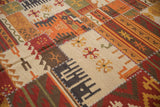 Patchwork Kilim rug close-up showing raised white cross stitches connecting warm-toned geometric panels.