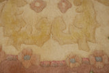 Close-up of vintage Indian Aubusson rug pile featuring ivory, rose, and powder blue floral motifs.
