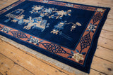 Terra cotta border with blue geometric fretwork and ivory floral motif on a vintage Peking rug.