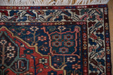 Corner detail of a vintage Baktiari rug showing intricate floral borders and clean white fringe.