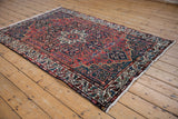 Vintage Baktiari rug with concentric medallions in brick red and indigo blue, seen from a high angle.