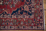 Corner detail of a Bakhtiari rug highlighting the navy spandrel, floral border, and white fringe.