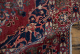 The supple body and even, low pile of a hand-knotted vintage Baktiari rug in red and navy.
