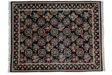 Vintage Indian Arts and Crafts carpet with floral roundel medallions in rows across a black field.