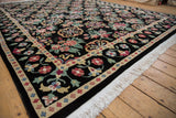 Corner of a vintage Indian carpet highlighting the plush pile, colorful floral medallions, and fringe.