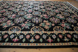 Angled view of a vintage Indian rug highlighting the thick, plush pile and colorful floral motifs.