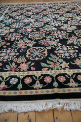 Side profile showing the plush pile, floral border, and ivory fringe of the vintage Arts and Crafts rug.