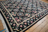 Angled view of the vintage Indian carpet's lush pile and detailed floral border.