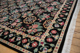 Angled view of the vintage carpet's corner, showing the floral border and thick, plush pile.