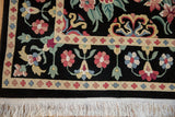 Detail of the vintage carpet's corner, highlighting the floral border design and clean, thick white fringe.