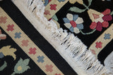 Detail view of the vintage carpet's intact ivory fringe, side cord selvage, and dense, full pile.
