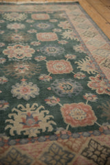 Dusty green Arts and Crafts rug detail: blossomed blush, blue florals and geometric border.