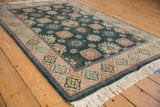 Ivory fringe and geometric blush, powder blue border on vintage Indian rug corner.