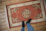 Vintage Peking rug corner with pictorial dragon, decorative ivory border, and plush original fringe.