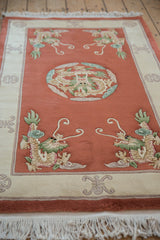Pictorial corner dragon in celadon green, ivory, and mauve on the terra cotta field.