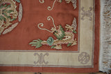 Sharp detailing on a vintage Peking rug corner, showing terra cotta dragon and ivory fringe.