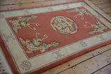 Peking rug corner with pictorial dragon, plush terra cotta pile, and ivory border.