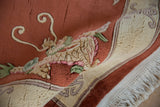 Plush pictorial dragon detail on vintage Peking rug in terra cotta, ivory, and mauve.