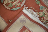 Folded corner of vintage Chinese Peking rug, plush terra cotta pile, tight back, ivory fringe.