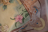 Embossed mauve flowers and seafoam green leaves on a textured vintage Chinese rug.