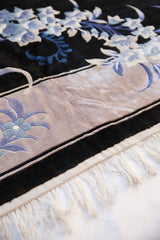 White fringe and high sheen simulated silk pile on platinum border with denim blue floral.
