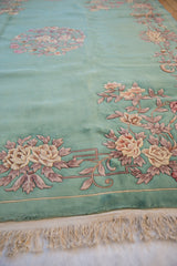 Embossed ivory, rose, and mauve floral motifs on mint green Art Deco pile.