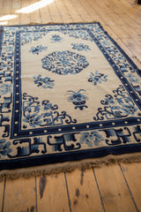 Vintage Peking rug corner, cobalt blue border, pearl line, floral vases, fringe.
