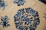 Lustrous ivory wool pile highlighting cobalt blue floral petals and arabesques.