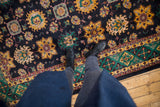 Rich navy vintage Agra carpet with saffron palmettes, emerald green floral border.